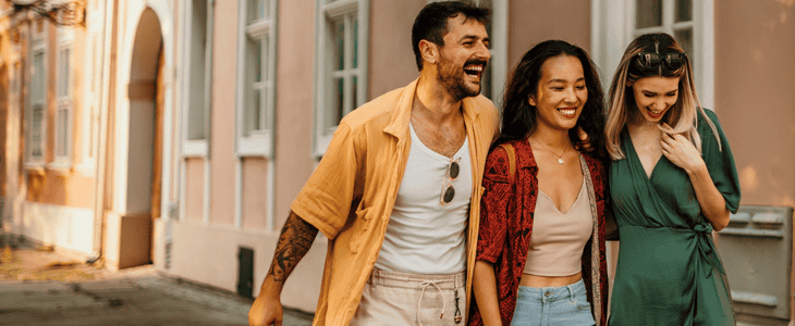 A group of friends laugh and walk together while exploring a new city